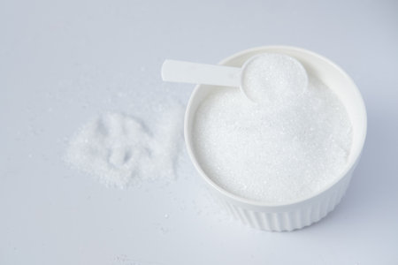 Epsom salts in a bath measuring spoon on a white background. Useful salt for relaxation in the bath. Magnesium saltの写真素材