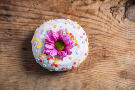 chrysanthemum bud on top of donut on wooden background. Delicate frame with pink flowerの写真素材