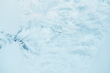 Beautiful frosty patterns on a blue windowの写真素材