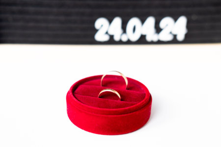 Rings of the newlyweds on the background of a Beautiful date for the wedding 04.24.2024 on a black...