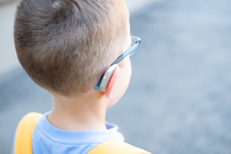 hearing aids in the ears of a 10-year-old boy on the street, close-upの写真素材