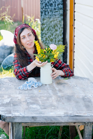 portrait of a smiling farmer girl with a bouquet of flowers on the streetの写真素材