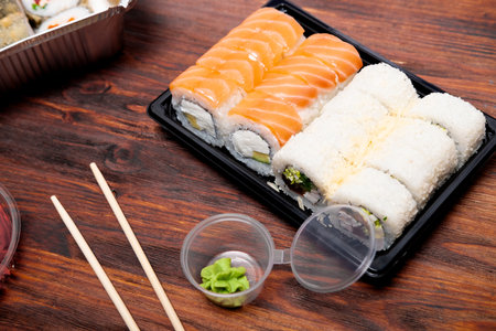 assorted rolls on a wooden background. Delivery of Asian food from a restaurantの写真素材