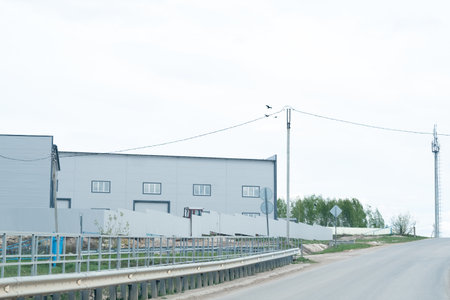 factory building on the road, against the background of a cloudy sky, copy spaceの写真素材