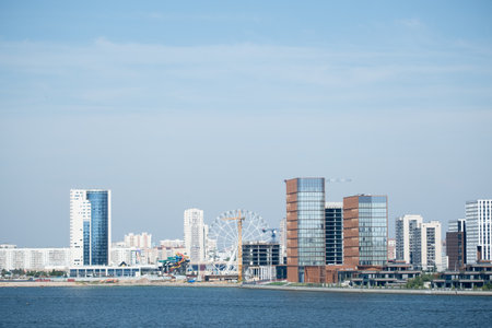A beautiful view of the modern city with high-rise buildings and a Ferris wheel on the embankment, viewed from the Kazanka River. Kazan, Russia - August 31, 2025のeditorial素材