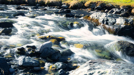 Mountain river flow through rocks and stones long exposure picture at Davos Switzerland