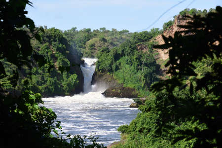 Waterfall in beautiful green forest with white water, rocks, roaring water, Murchison Falls National Park Ugandaの写真素材