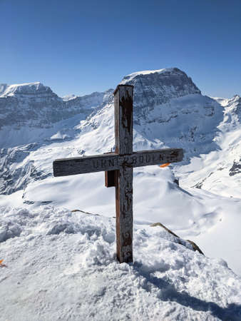 summit cross on the gemsfairenstock with a view of the piz russein toedi. Urnerboden. Winter mountain landscape. Peakの写真素材