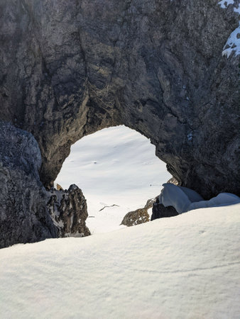 round hole in the rock, ski tour from the fisetenpass towards gemsfairenstock, large hole in the rock.ski mountaineeringの写真素材