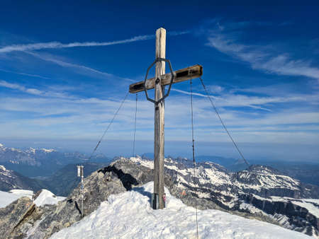 summit cross on the mountain clariden in the canton glarus uri. Ski mountaineering over the glacier breathtaking viewの写真素材