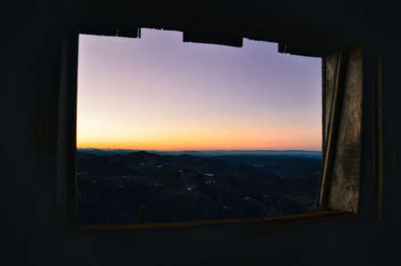 sunset seen from a cowshed window. Sunset in the backcountry switzerlandの写真素材