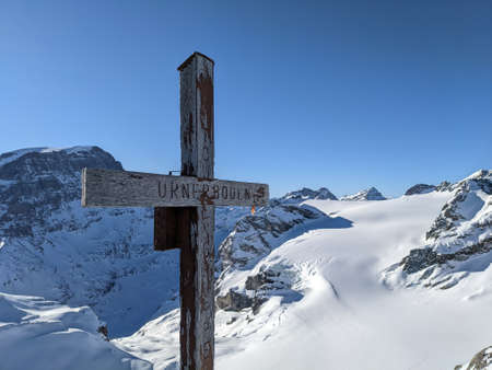 on the gemsfairenstock mountain above unerboden in the canton of uri. Beautiful view of the snow-covered mountains with a cross on the summitの写真素材
