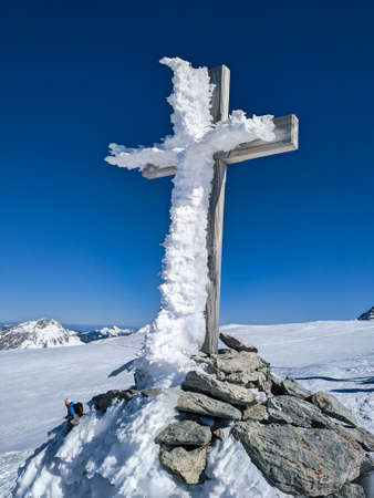 Winter peak crosses with a lot of snow and ice. snow cross. summit crossed on the mountain silberen. Ski mountaineering.の写真素材