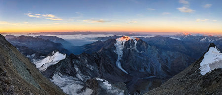 Sunrise on the summit climb of the Grand Combin. View of the Mont Velan mountain. mountaineering in...