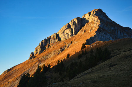 Hiking in the Swiss Alps. Mountain climbing on the Fronalpstock in Glarus. Beautiful autumn atmosphere with snow on the shady slopes. Wanderlust in Switzerland.の写真素材
