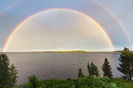 Double colorful rainbow over the lakeの写真素材