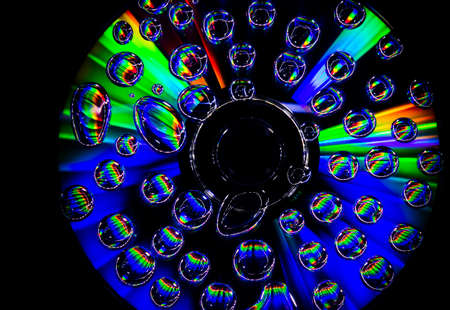 CD with great lights, flares and waterdrops on the surface on black backgroundの写真素材