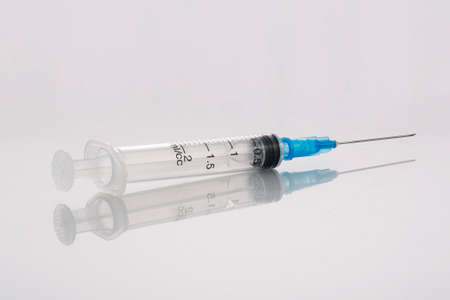 Medical syringe on grey background with reflectionの写真素材