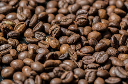 Coffee beans on black surface background photo