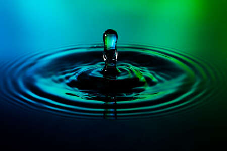 Water drop on green blue background macro
