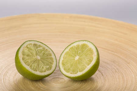 Fresh lime slices on wood plate closeupの写真素材