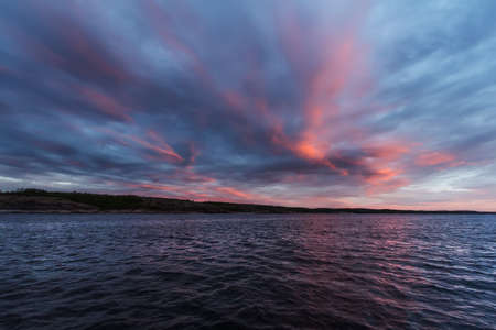 Amazing sunset over sea with pink sky and clouds in Russiaの写真素材