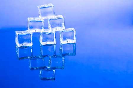 ice cubes put on each other on blue background.の写真素材