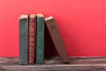 Vintage old books on wooden table with red background.の写真素材
