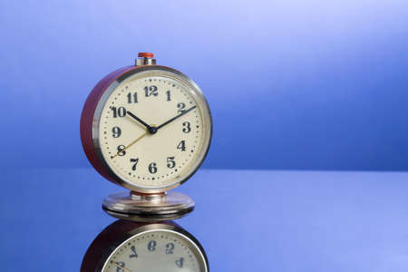 retro clock on nice blue background with reflection.