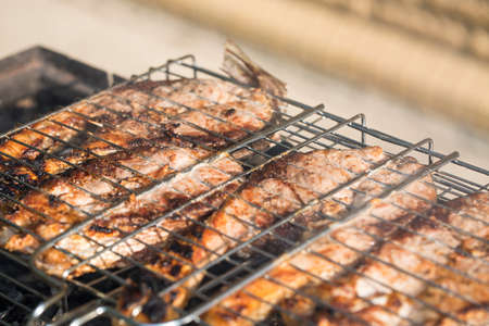 pieces of silver carp roasted close up on grill plate tasty diet fish meal.の写真素材