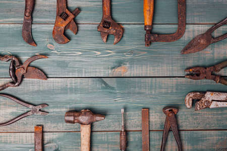 different rusty construction instruments on the green wooden background.の写真素材