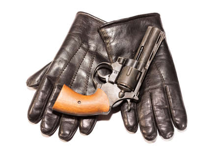 Mafia concept. Black gun on leather gloves isolated on white background.の写真素材