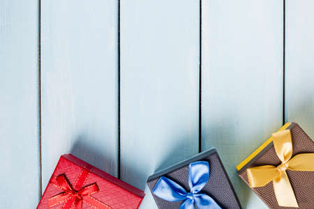 Colorful gift boxes on nice blue wooden background with free space.