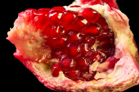 ruby juicy pomegranate grains closeup on black background. Macro shotの写真素材
