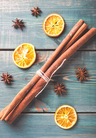 Dried orange, anise and cinnamon sticks on green wooden table. Toned photo.の写真素材