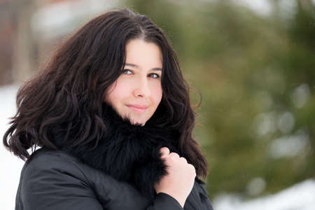 Winter portrait of young beautiful brunette woman snood covered in snow. Snowing winter beauty fashion concept.の写真素材