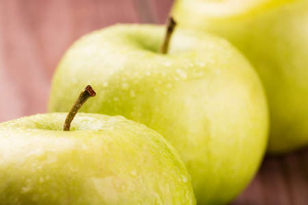 Green apples with stems and water drops close upの写真素材