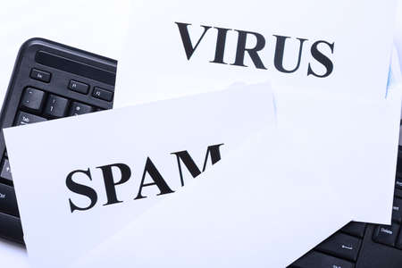 SPAM and VIRUS in envelope on white black keyboard close-up