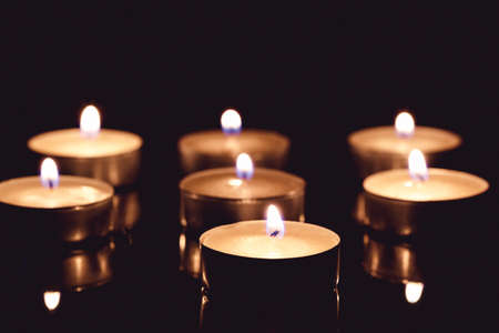 Group of tea candles on a black background. Selective focus.の写真素材