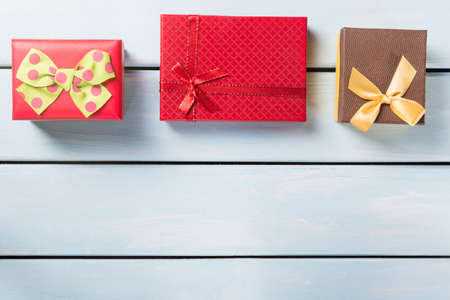 Colorful gift boxes on nice blue wooden background with free space.