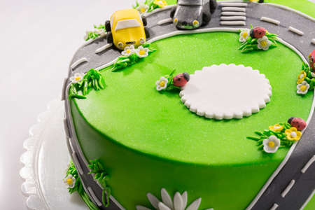 Delicious cake with ladybug and cars with free place for text close up.の写真素材