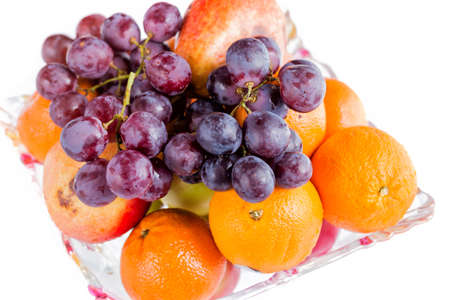 Oranges and grape in a bowl close uo isolated on white