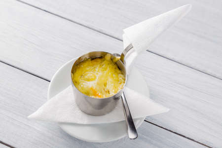 Julienne with chicken and mushrooms in a bowl on white wooden background.の写真素材