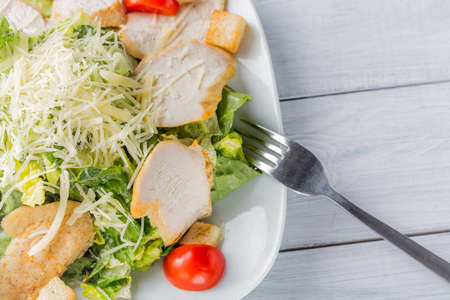 Healthy green organic caesar salad close up on white plate and fork.の写真素材