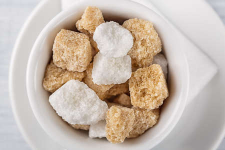 White sugar and brown sugar cane cube in white bowl on white background. Close up image.の写真素材