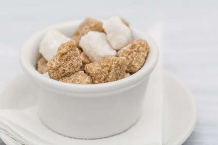 White sugar and brown sugar cane cube in white bowl on white background. Close up image.の写真素材