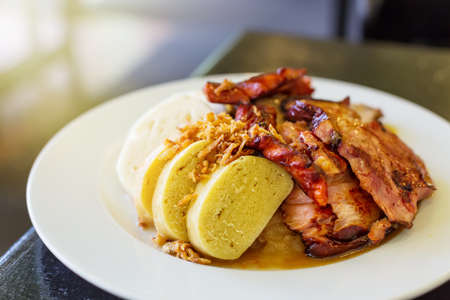 Czech traditional cuisine dumplings cabbage and pork meat on a plate.