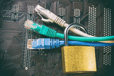 Network ethernet cables in padlock on computer motherboard. Internet data privacy information...