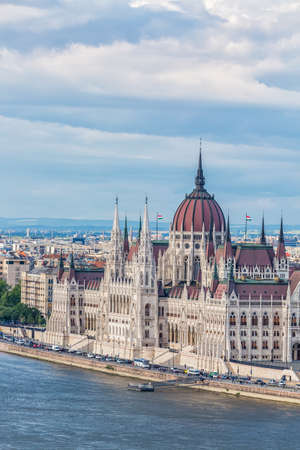 Travel and european tourism concept. Parliament and riverside in Budapest Hungary during summer sunny day with blue sky and clouds.の写真素材
