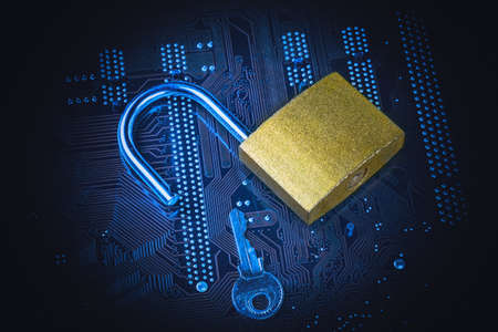 Opened padlock with a key on computer motherboard. Internet data privacy information security...